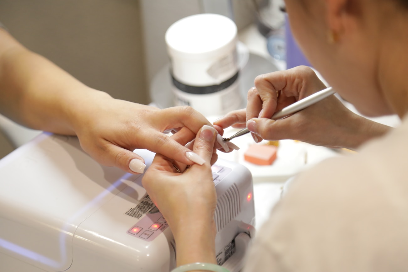 Nail technician carefully working on a client's nails at Harbor and Sage in Port Angeles