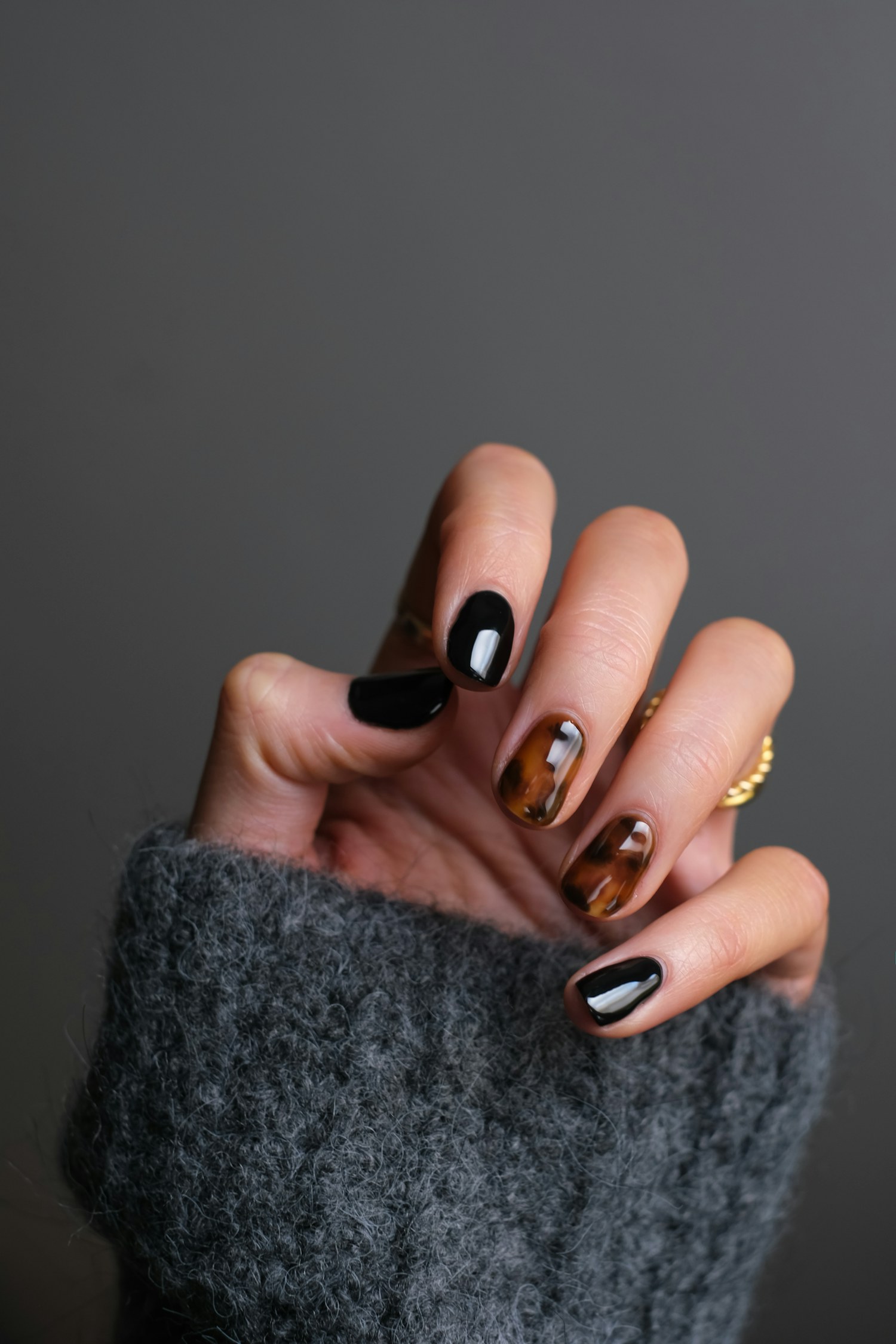 Elegant glossy manicure in warm tortoise and black tones — luxury nail care in Port Angeles, WA